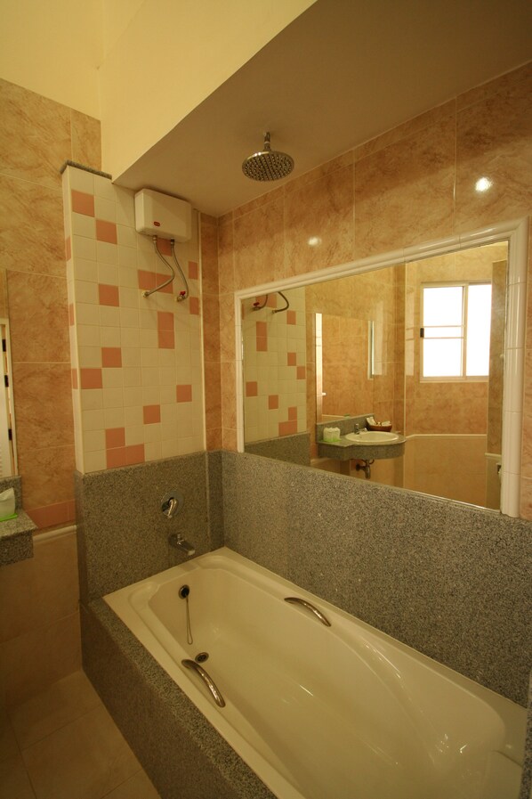 A bathroom with a bathtub, a shower, and a sink.