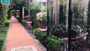 A pathway lined with potted plants and a sign indicating a family suite, restaurant, and spa massage services. - Budsaba Resort & Spa (Bang Lamung)