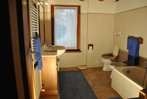 A bathroom with a sink, toilet, bathtub, and a window with blinds. - B&B Gemma (Grezzana)