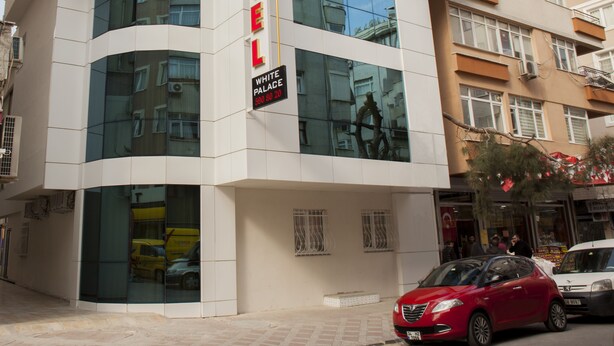 Un hotel moderno con un llamativo letrero que dice 'HOTEL', amplias ventanas y una dirección visible.