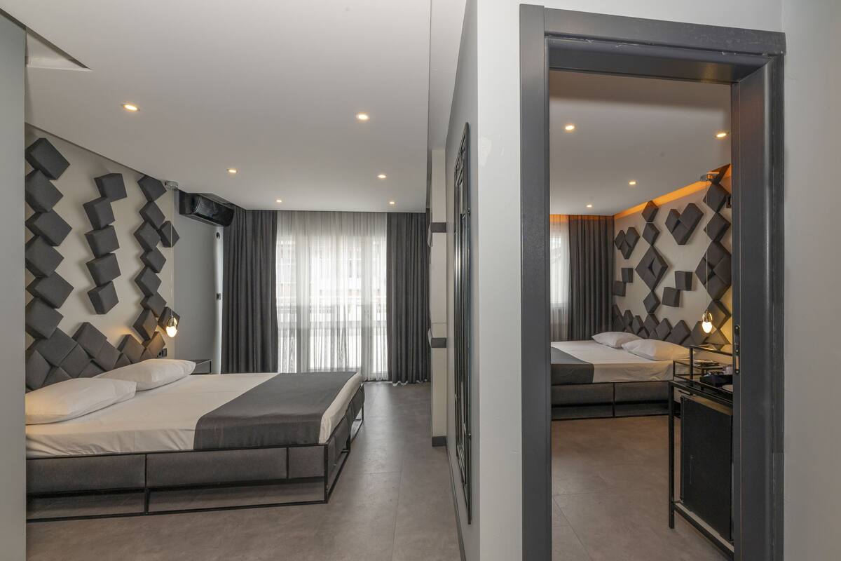 Ein modernes Hotelzimmer mit einem großen Bett, einem Schreibtisch und einem Spiegel.