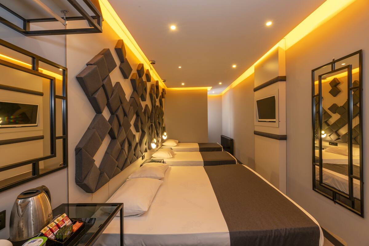 Ein Hotelzimmer im modernen Stil mit einem großen Bett, einer Sitzecke und einem an der Wand befestigten Fernseher.