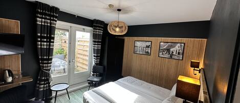 Un dormitorio moderno con cama, escritorio, silla y una mesita.