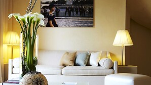 A modern living room with a beige sofa, a decorative vase with white flowers, and two lamps. - MUSE Saint Tropez (Ramatuelle)