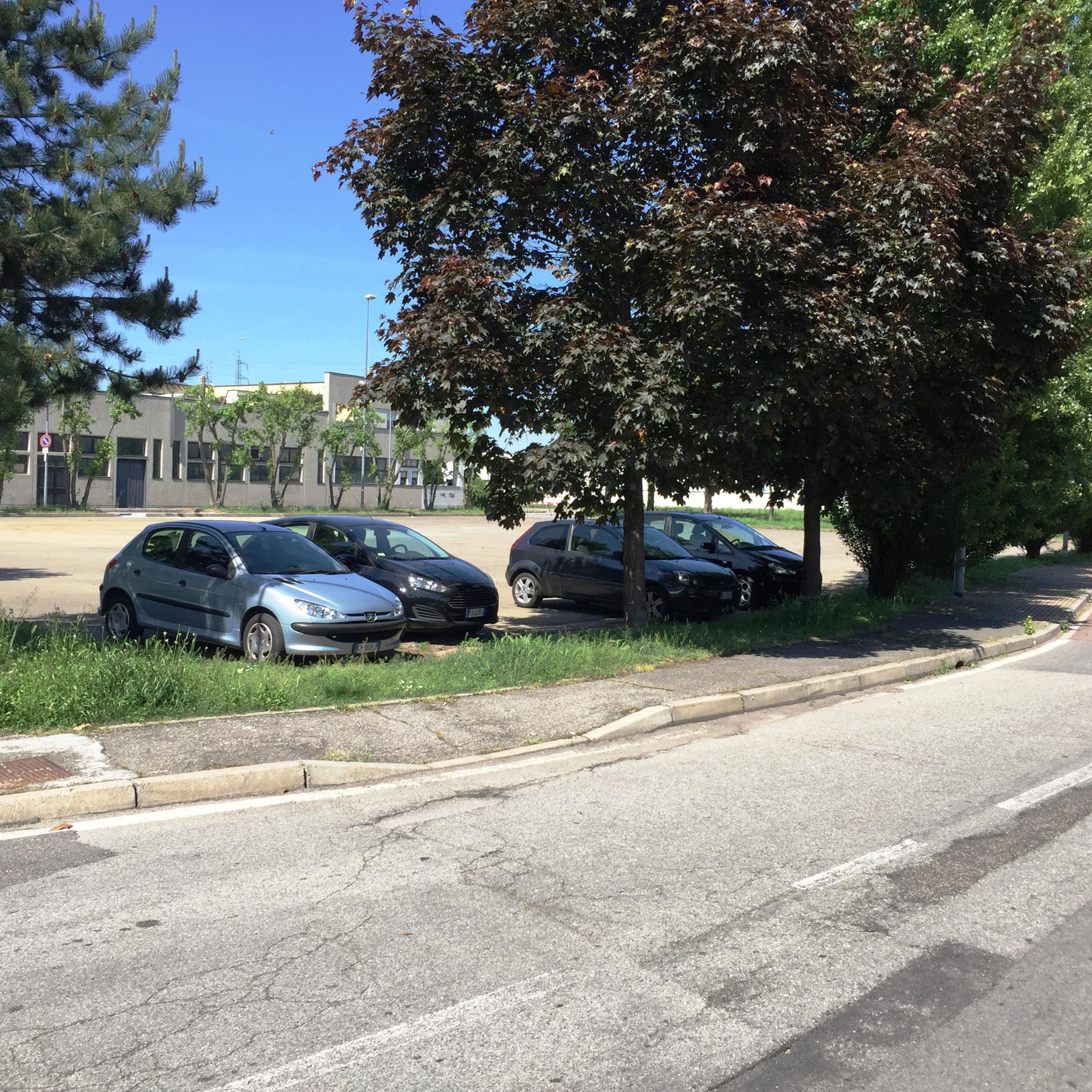 Ein Parkplatz mit mehreren Autos in der Nähe eines Gebäudes.