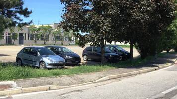 Ein Parkplatz mit mehreren Autos in der Nähe eines Gebäudes.