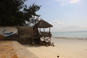 Na praia, areia branca, espreguiçadeiras 