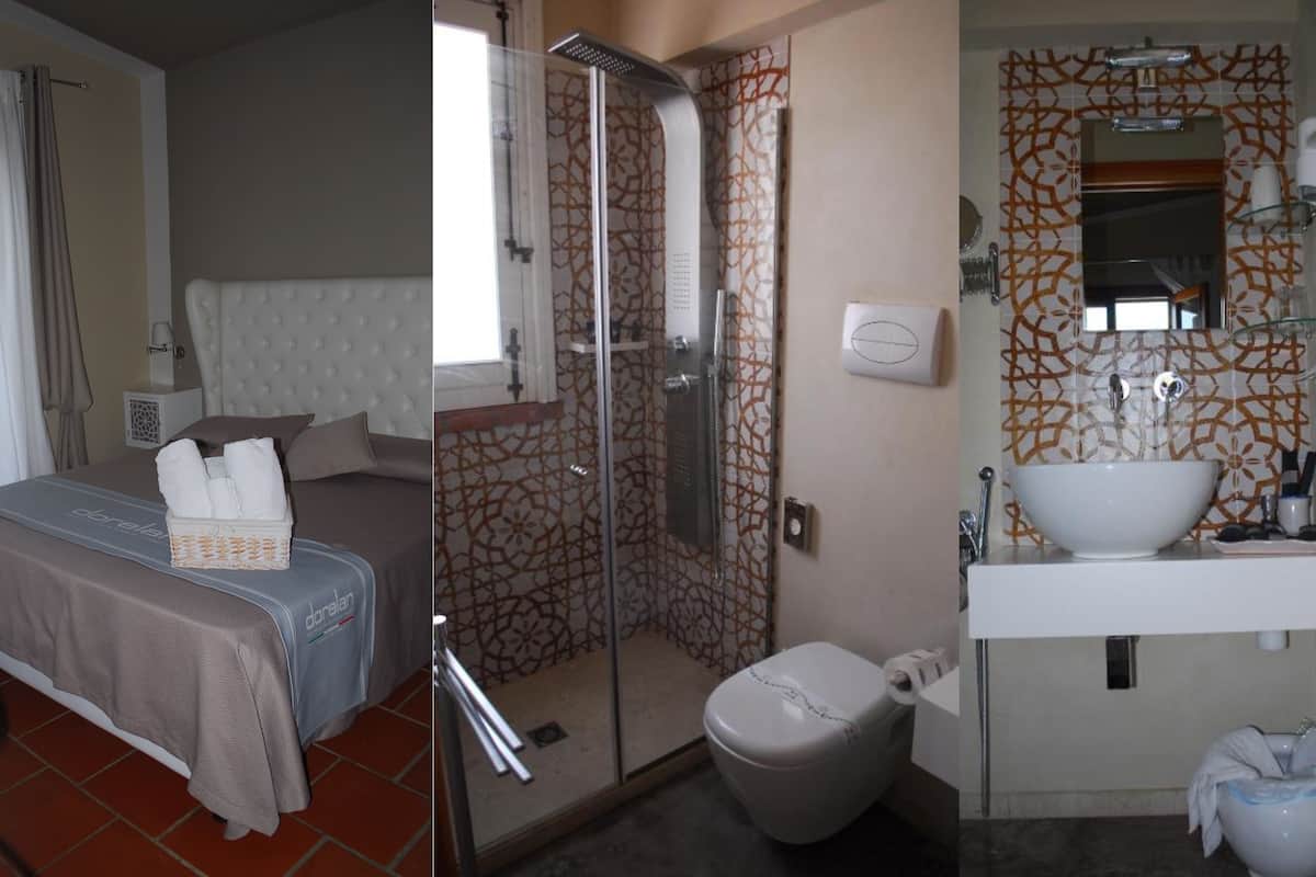 A hotel room with a bed, a bathroom with a shower, and a sink.