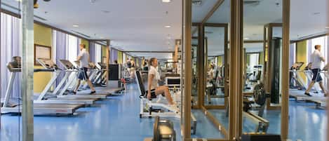 A gym with treadmills, exercise bikes, and weight machines.