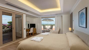 A hotel room with a bed, a desk, a TV, and a balcony with chairs.