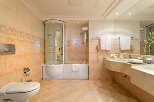 Un baño moderno con inodoro, bañera, ducha y tocador con lavabo.