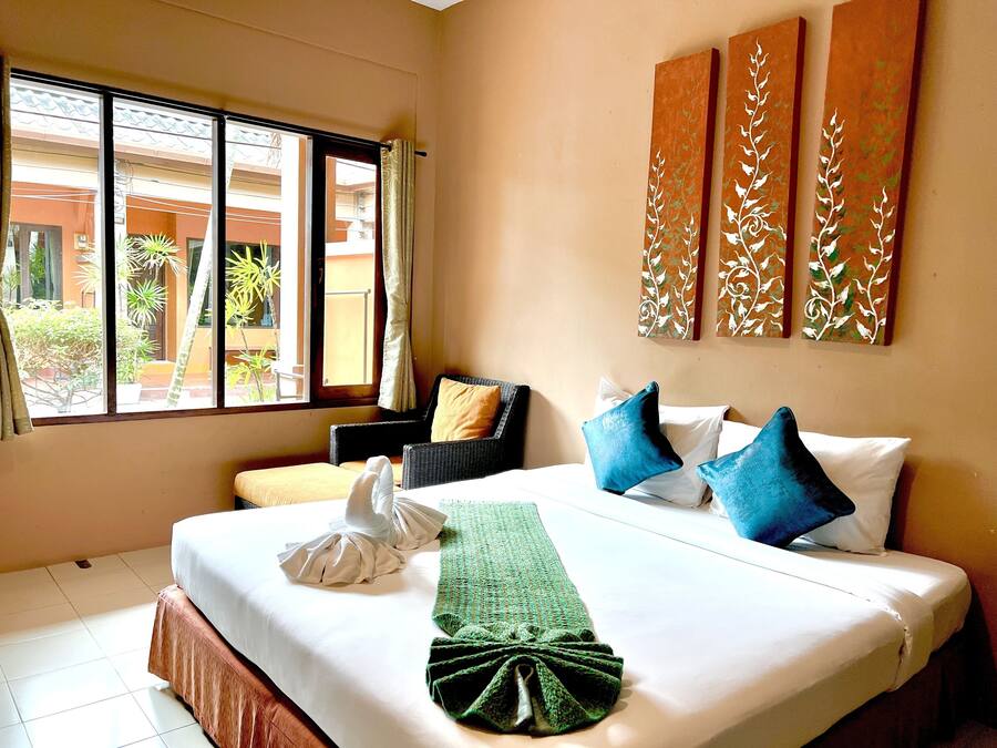 Habitación de hotel con cama, una silla y vistas al exterior.