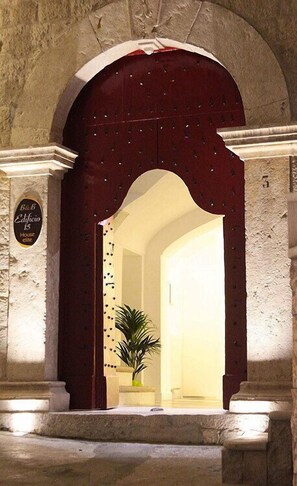 An arched doorway with a dark red door, a potted plant, and a sign reading "B&B Edificio 15". - Edificio 15 House Elite (Rodi Garganico)