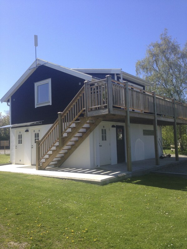 A two-story building with a wooden staircase and a balcony.