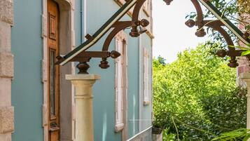 A building with a wooden door and a balcony with a metal railing.