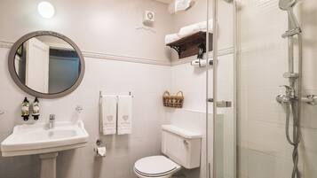 Une salle de bain avec un lavabo, des toilettes et une douche.