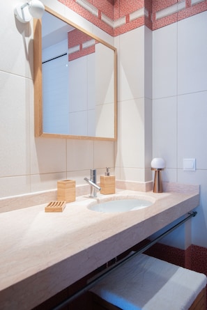 A bathroom with a large mirror, a sink, and a towel rack. - Dialiskari Villas (Trifylia)