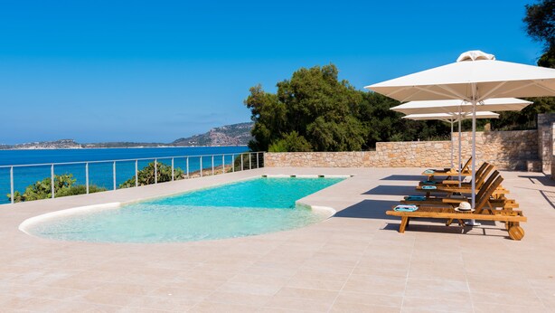 A swimming pool with a stone wall and a view of the sea. - Dialiskari Villas (Trifylia)