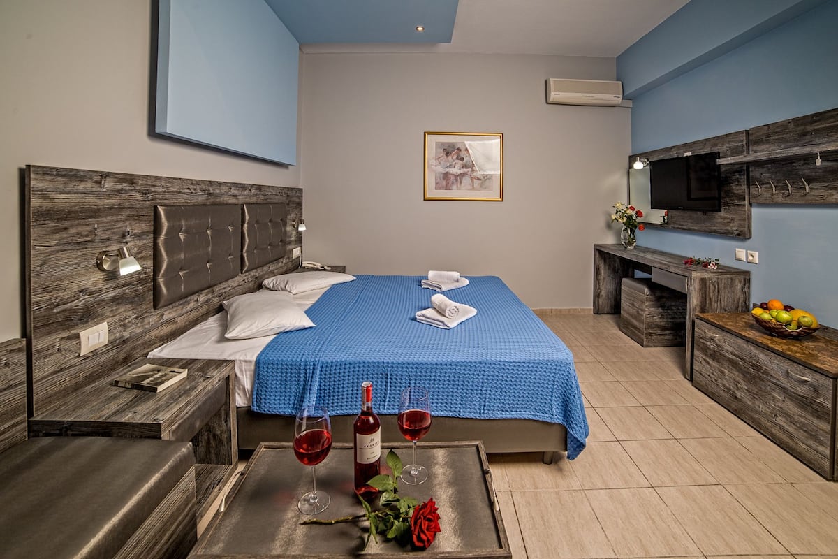 Ein Hotelzimmer mit Bett, Nachttischen, Fernseher und Obstkorb.