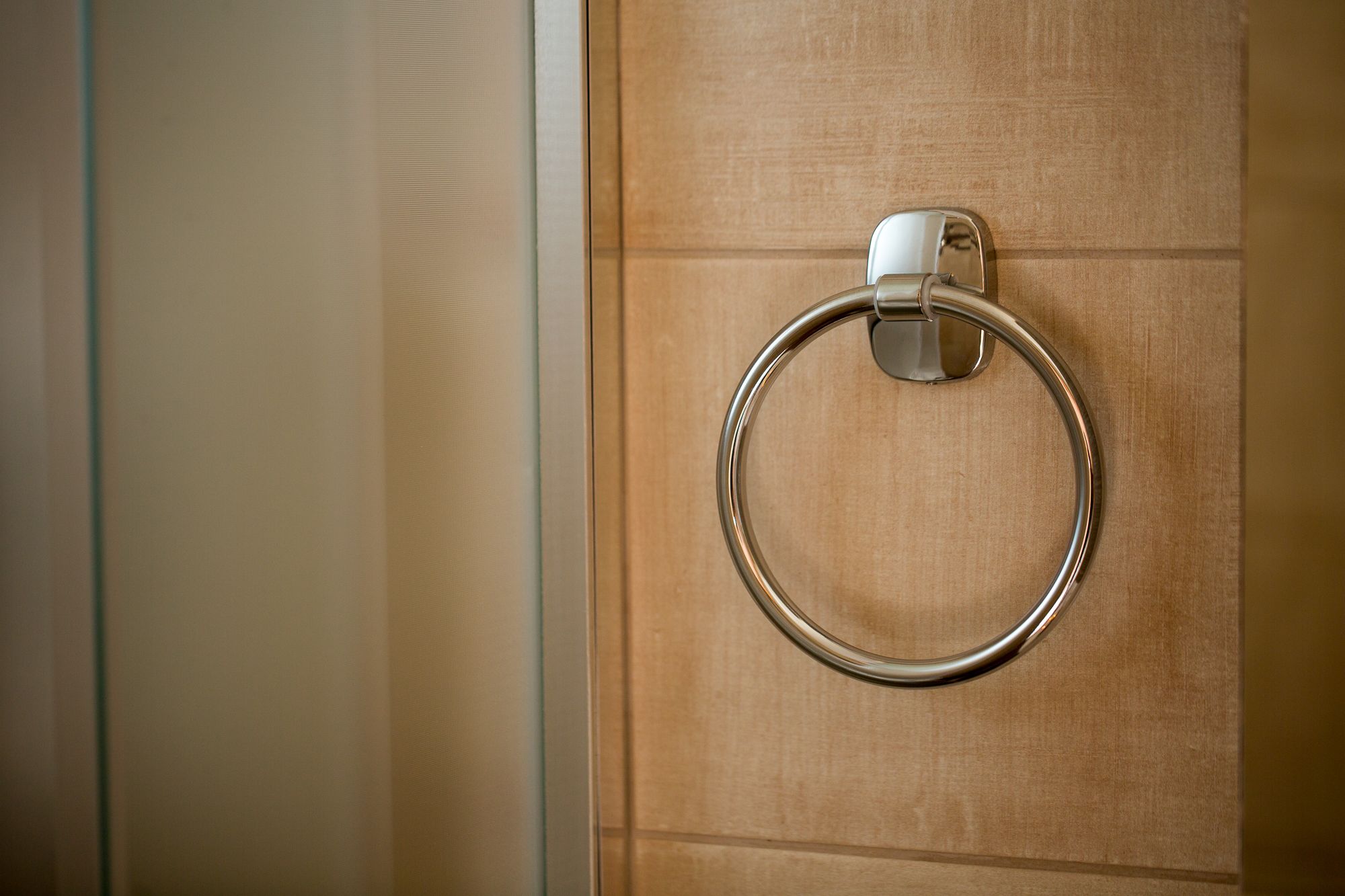 A metallic towel ring mounted on a wooden door.