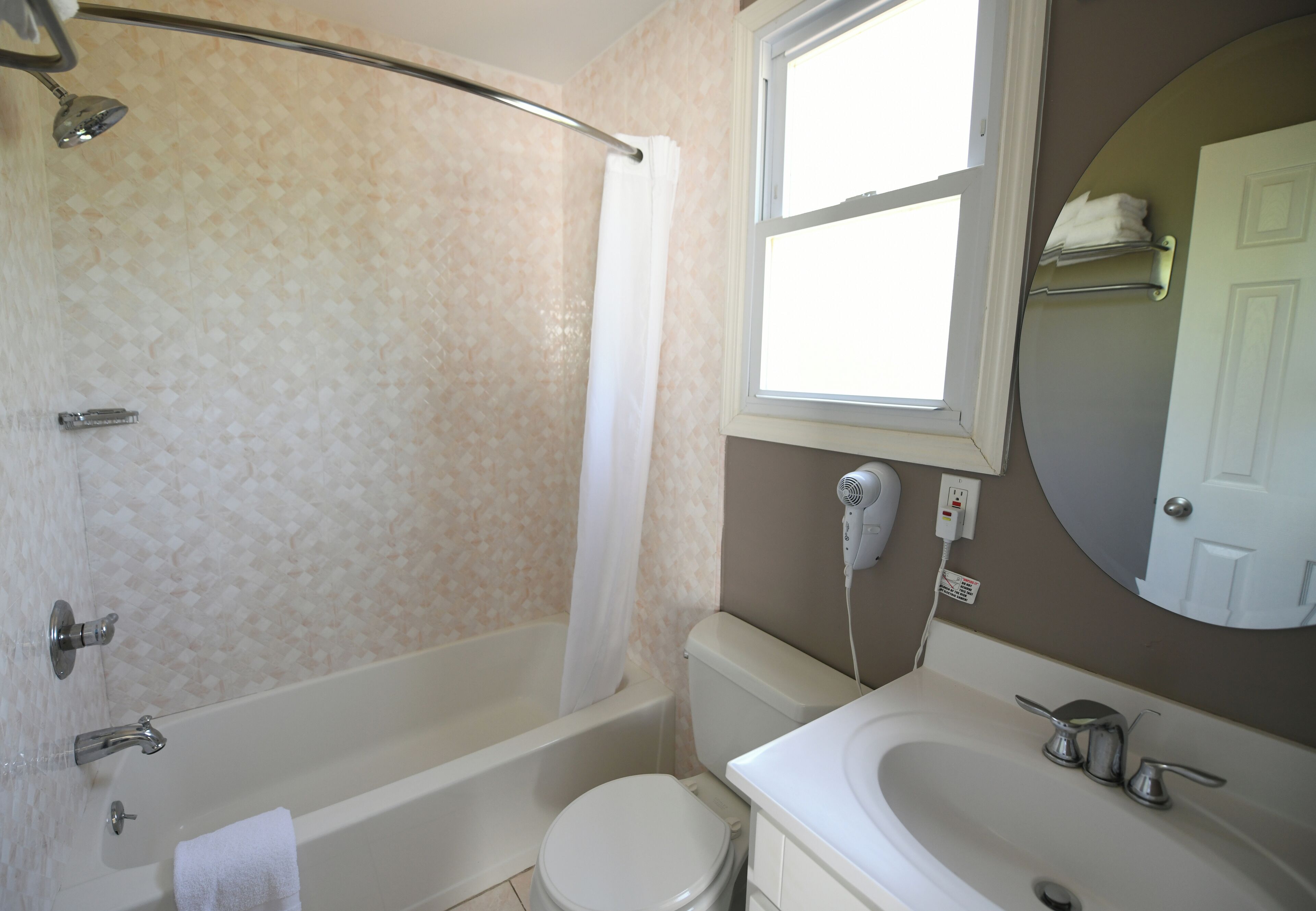 A bathroom with a bathtub, toilet, and sink.