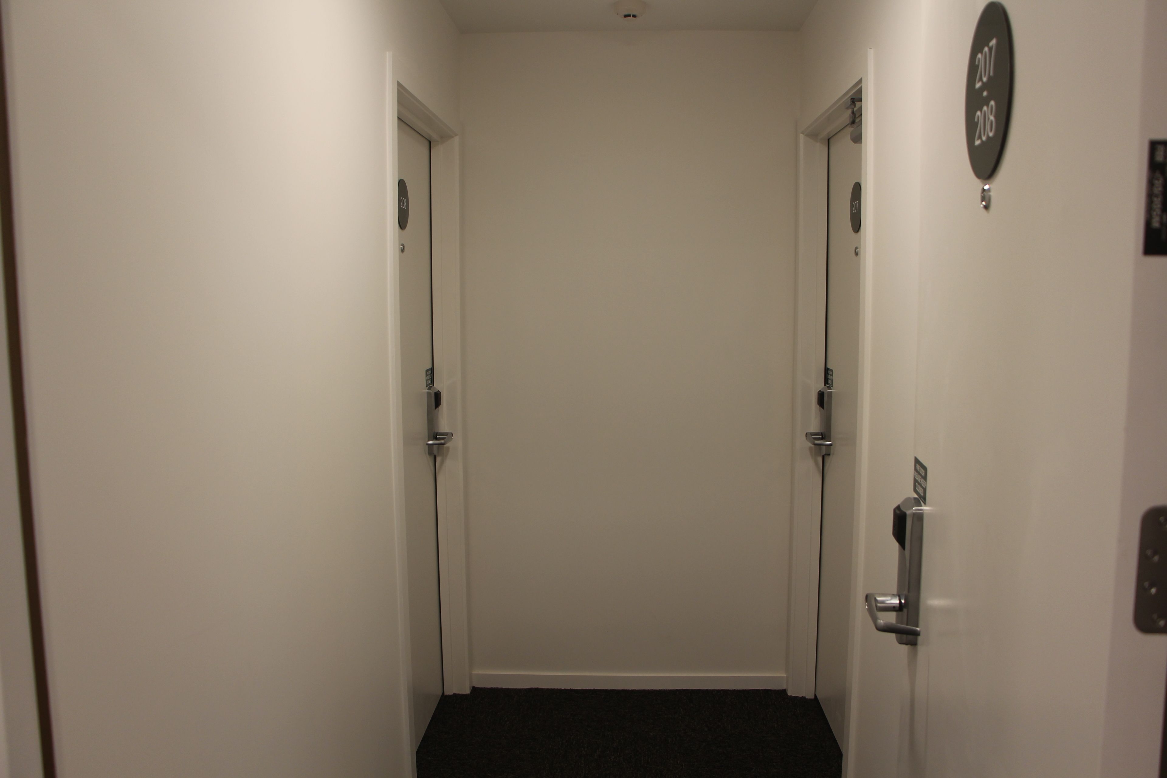 A narrow hallway with doors on both sides, each marked with a number.