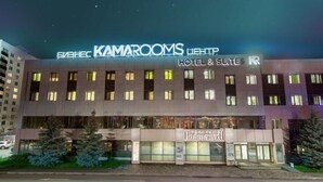 Un hotel con fachada moderna, varios pisos y un cartel que indica que ofrece habitaciones y suites.