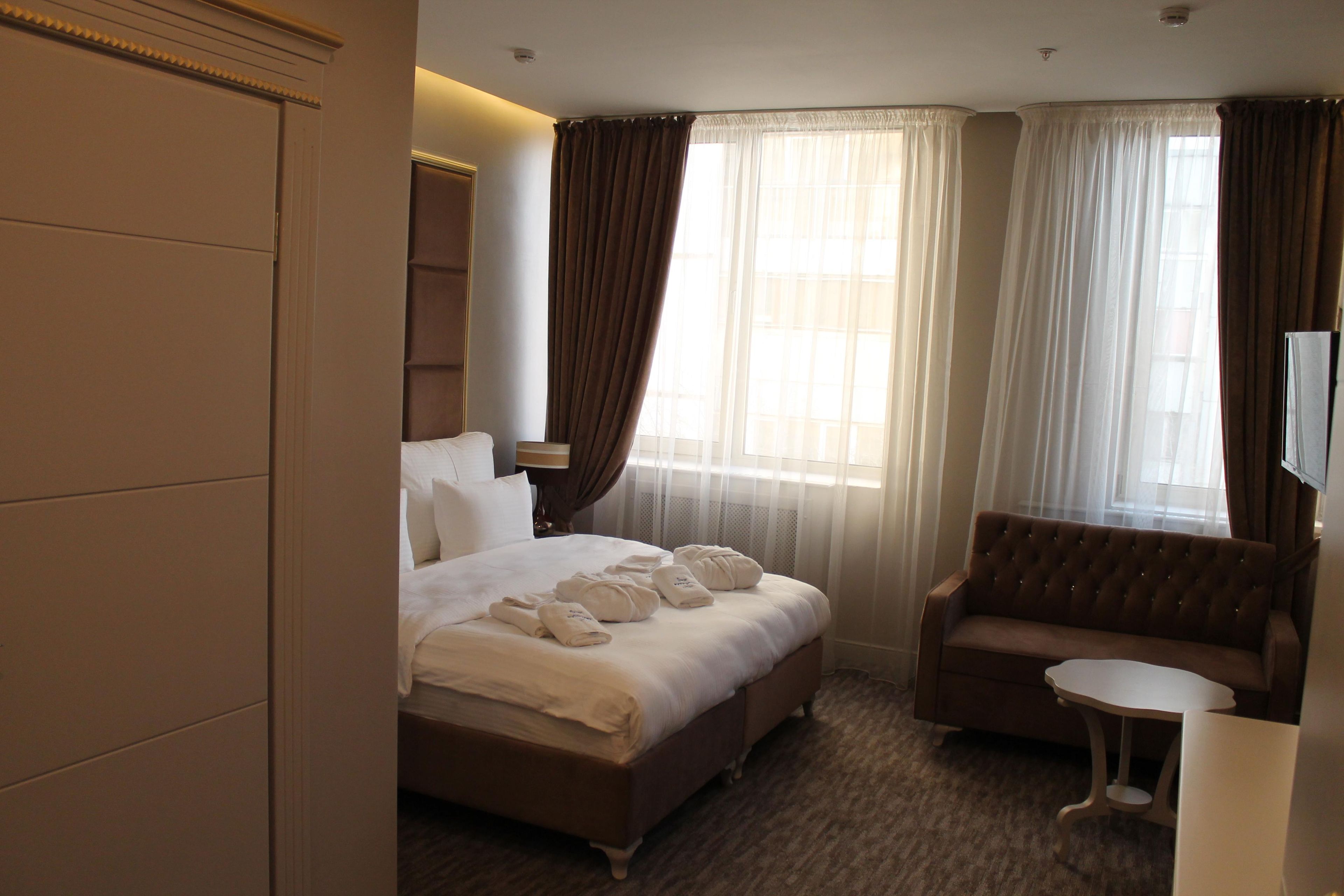 Une chambre d’hôtel avec un lit, un canapé, une petite table et un téléviseur.