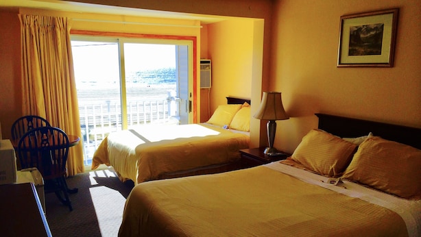 A hotel room with two beds, a desk, a chair, and a window with curtains. - Moulton Hotel (Hampton)