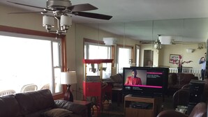 A living room with a television, leather sofas, a coffee table, and a ceiling fan. - Moulton Hotel (Hampton)