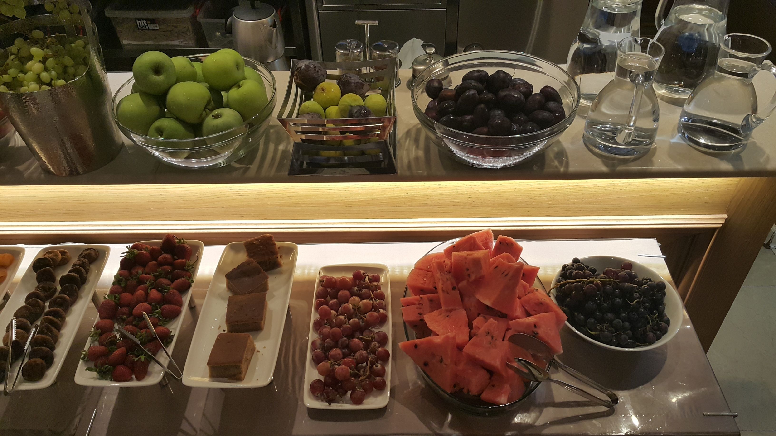 A buffet with various fruits and desserts.