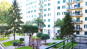 A multi-story residential building with balconies, a courtyard with benches, and well-maintained greenery. - Hotel Geo (Rome)