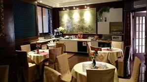 A restaurant with round tables, chairs, and a counter with a coffee machine. - Hotel Geo (Rome)