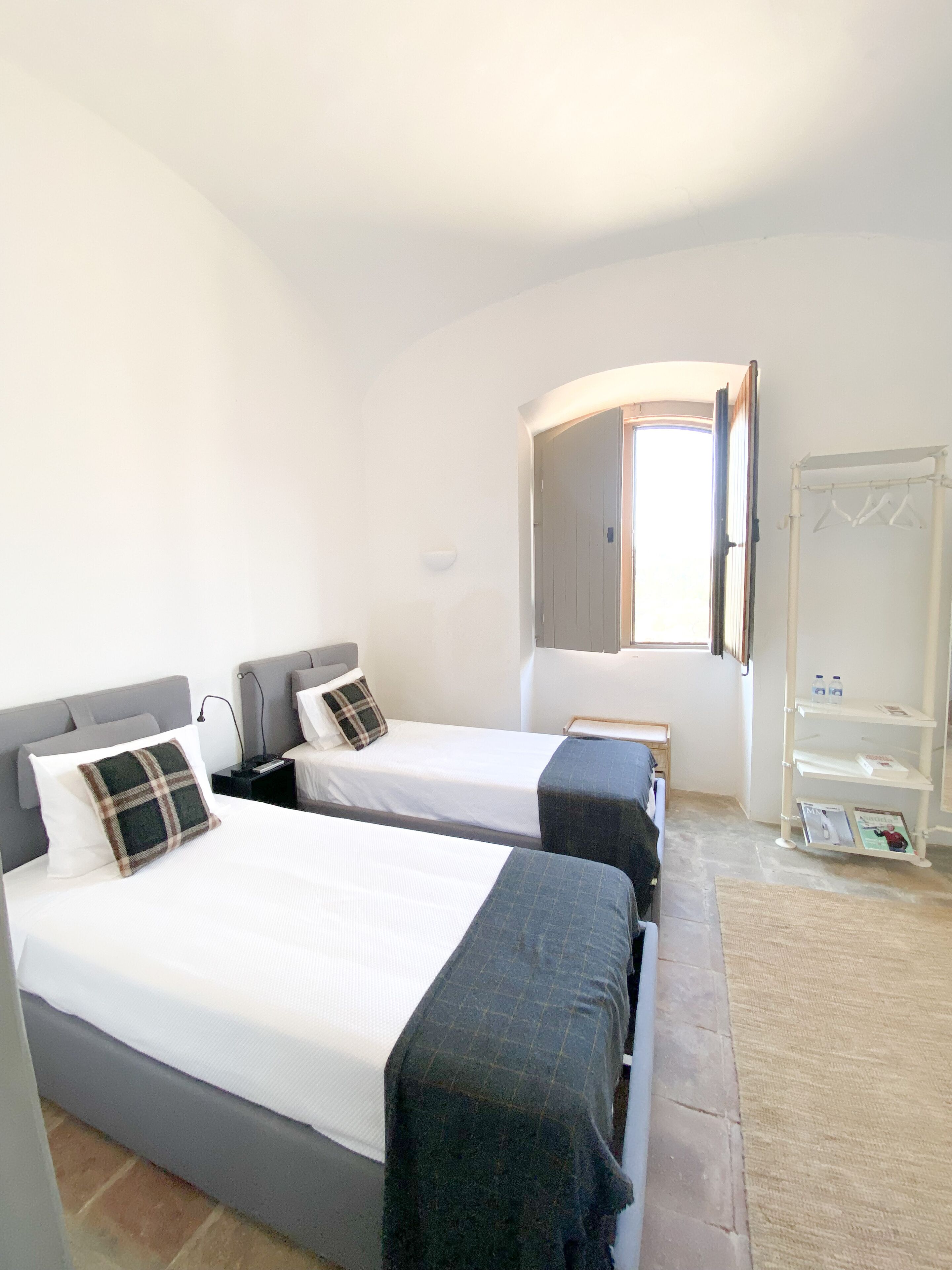 Une chambre avec deux lits, une armoire et une fenêtre.
