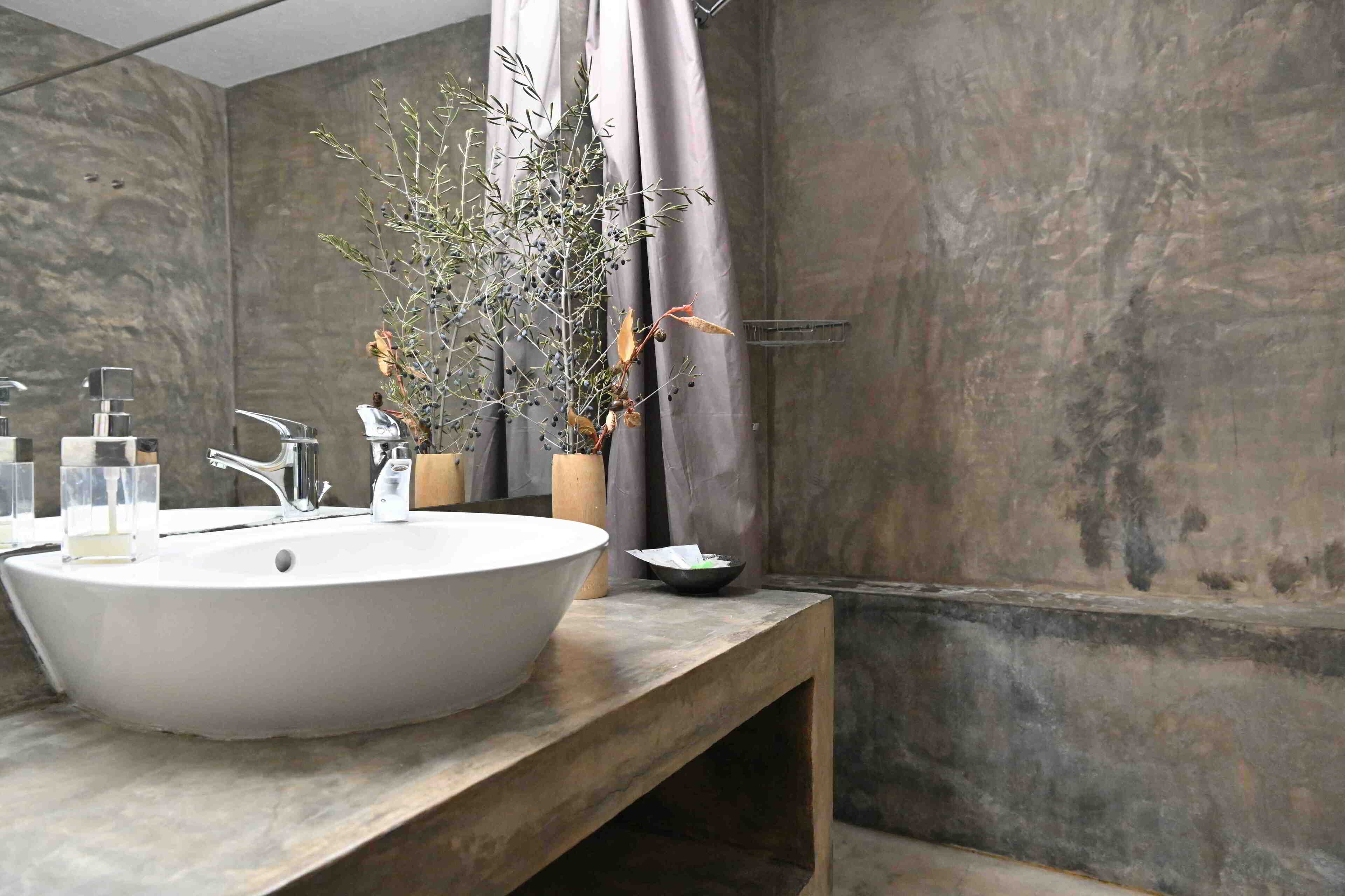 A modern bathroom with a large freestanding bathtub, a wooden vanity, and a mirror above the sink.