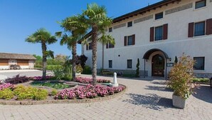 A building with a courtyard featuring palm trees, a fountain, and flower beds.