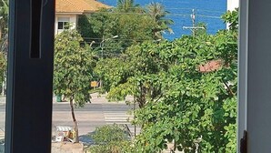 A view from a window overlooking a street with buildings and a clear blue sky. - Victoria Phu Quoc Hotel (Phu Quoc)