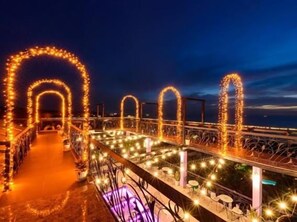 A pathway with arches and lights, leading to a structure with a railing. - Victoria Phu Quoc Hotel (Phu Quoc)