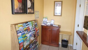 A reception area with a bulletin board, a desk, and a trash bin. - National City Motel (National City)