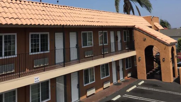 A two-story building with a tiled roof and a balcony. - National City Motel (National City)