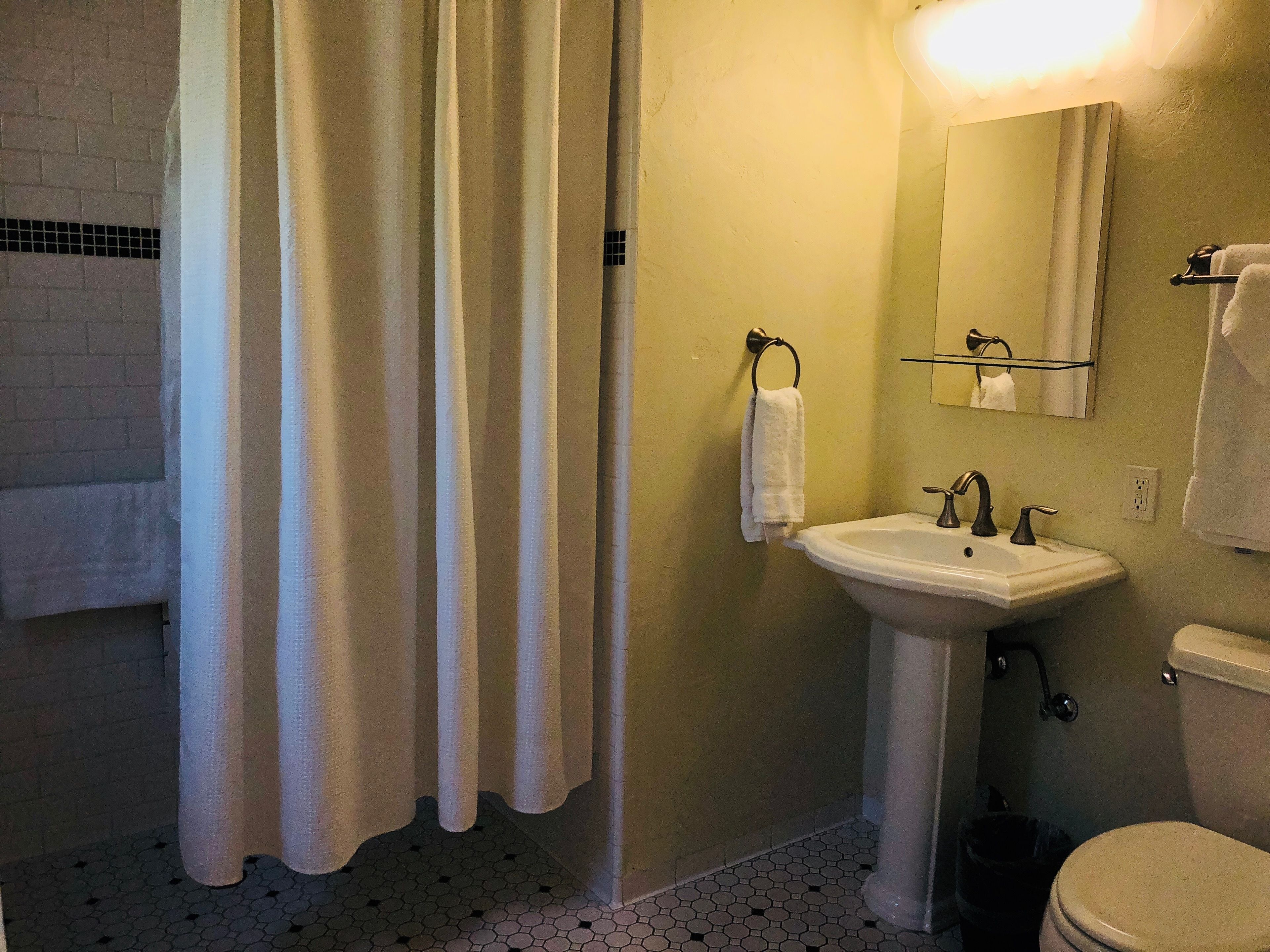 A bathroom with a white sink, a toilet, and a shower curtain.