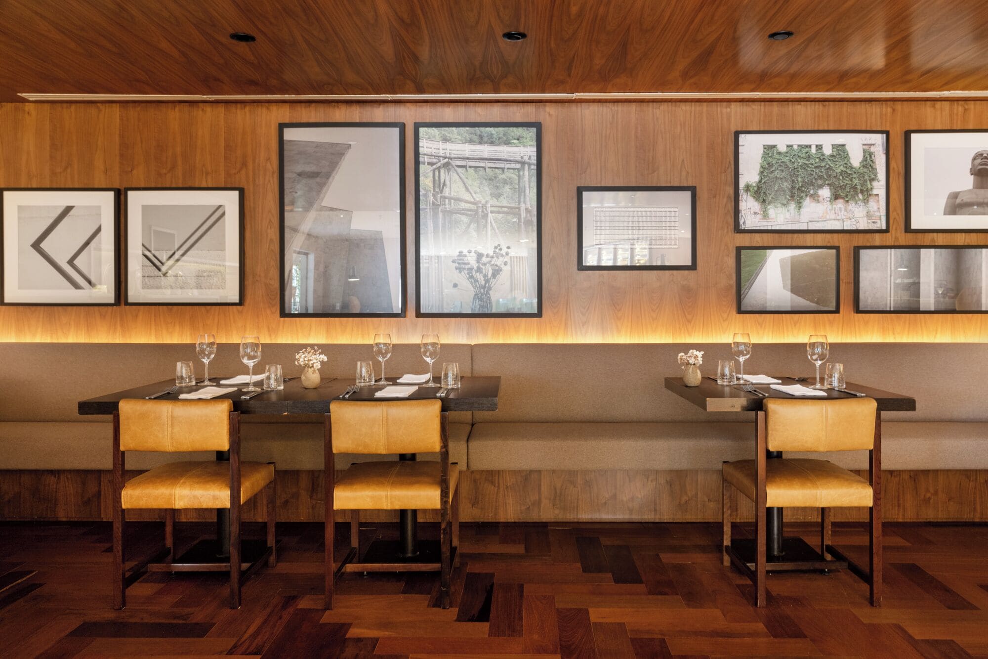 Un restaurant aux murs lambrés, orné d’œuvres d’art encadrées, et doté d’un parquet en point de Hongrie.