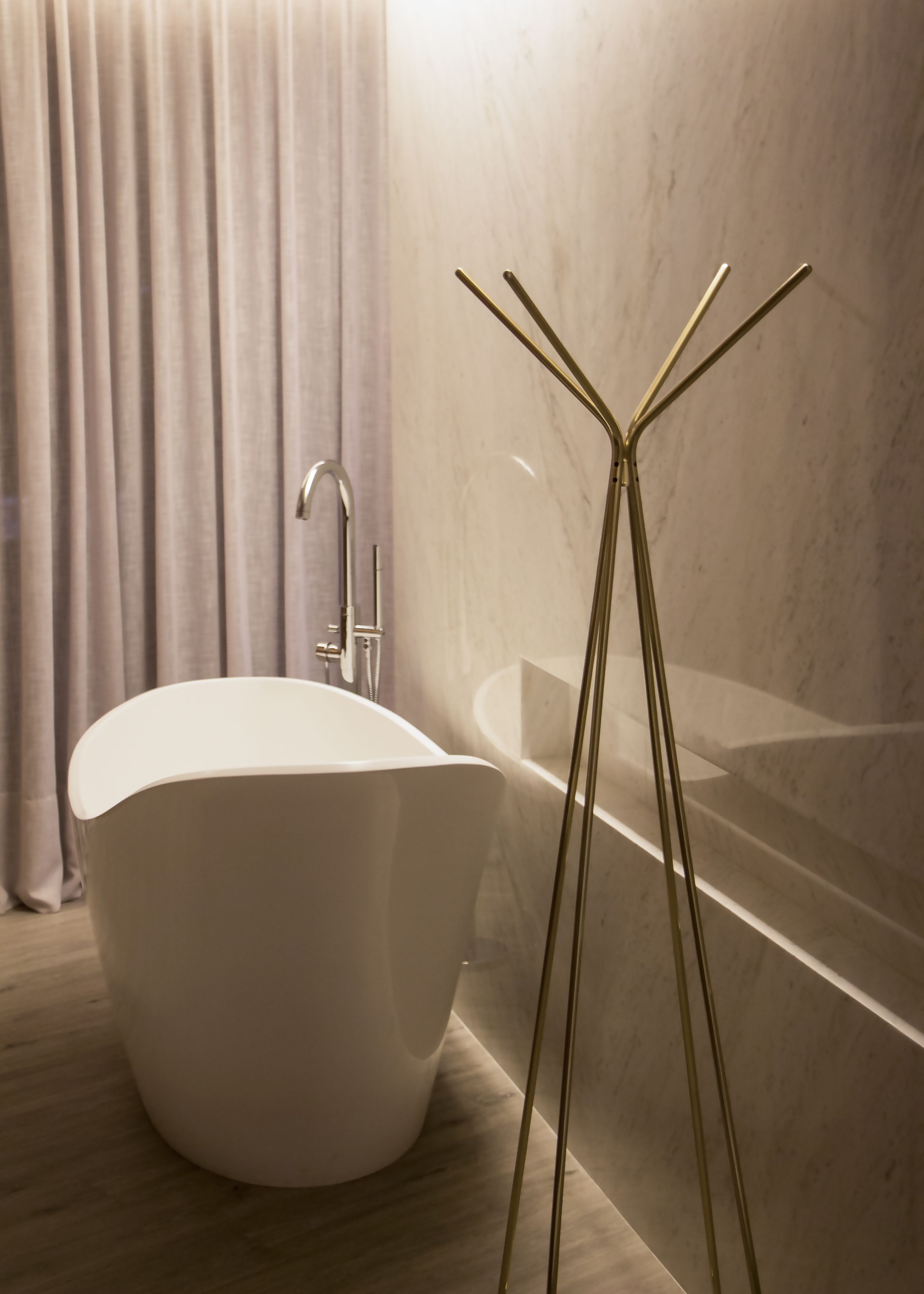A modern bathroom with a freestanding bathtub, a shower, and a glass-enclosed toilet.
