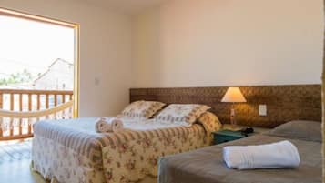 Una camera da letto con due letti, un balcone in legno e una lampada sul comodino.