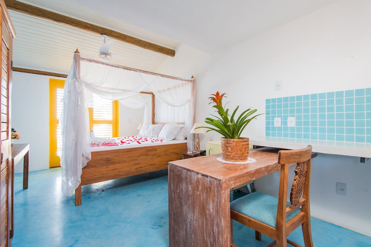 A room with a bed, a wooden table, and a chair.