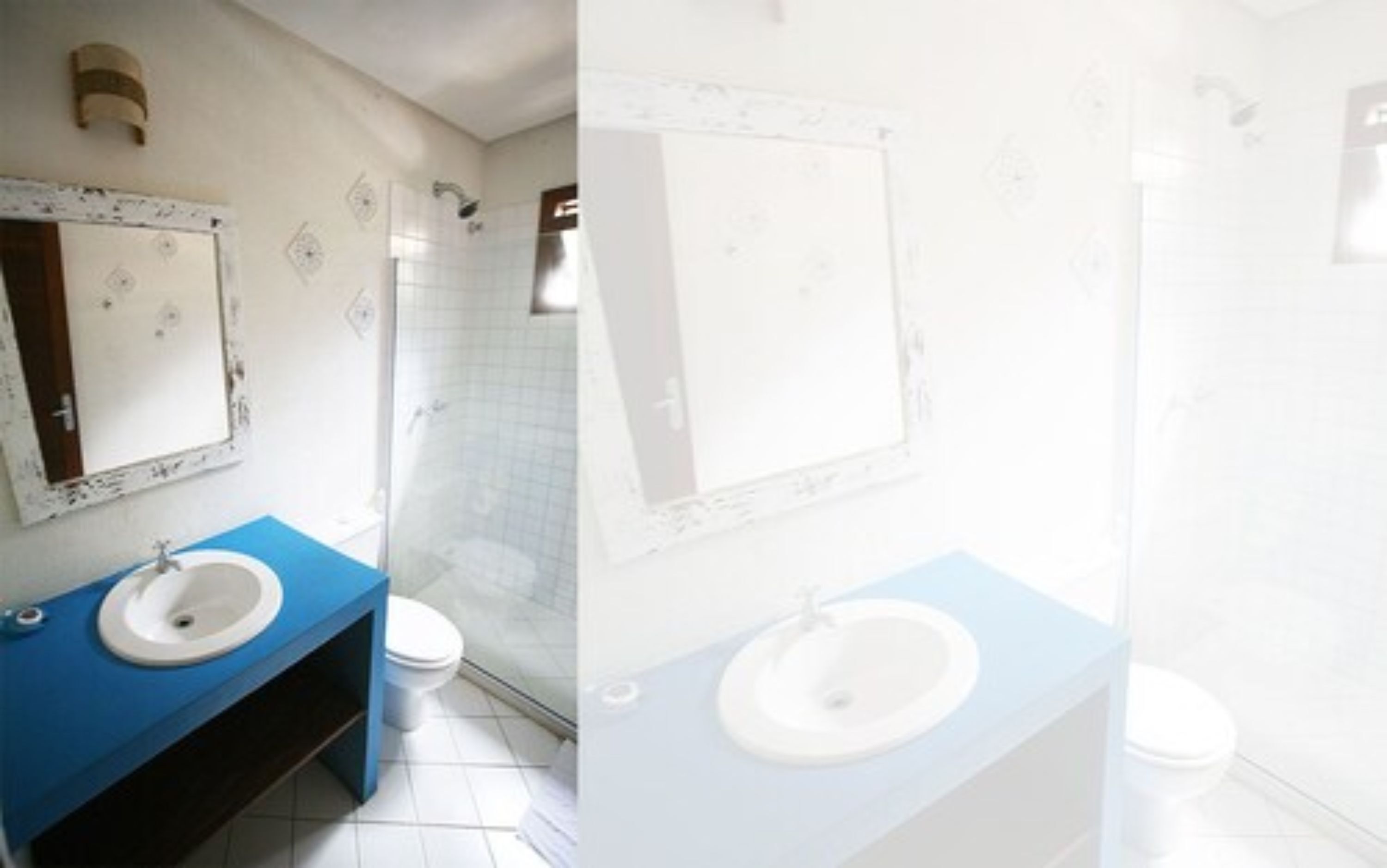 Un baño con tocador azul, lavamanos blanco y zona de ducha.