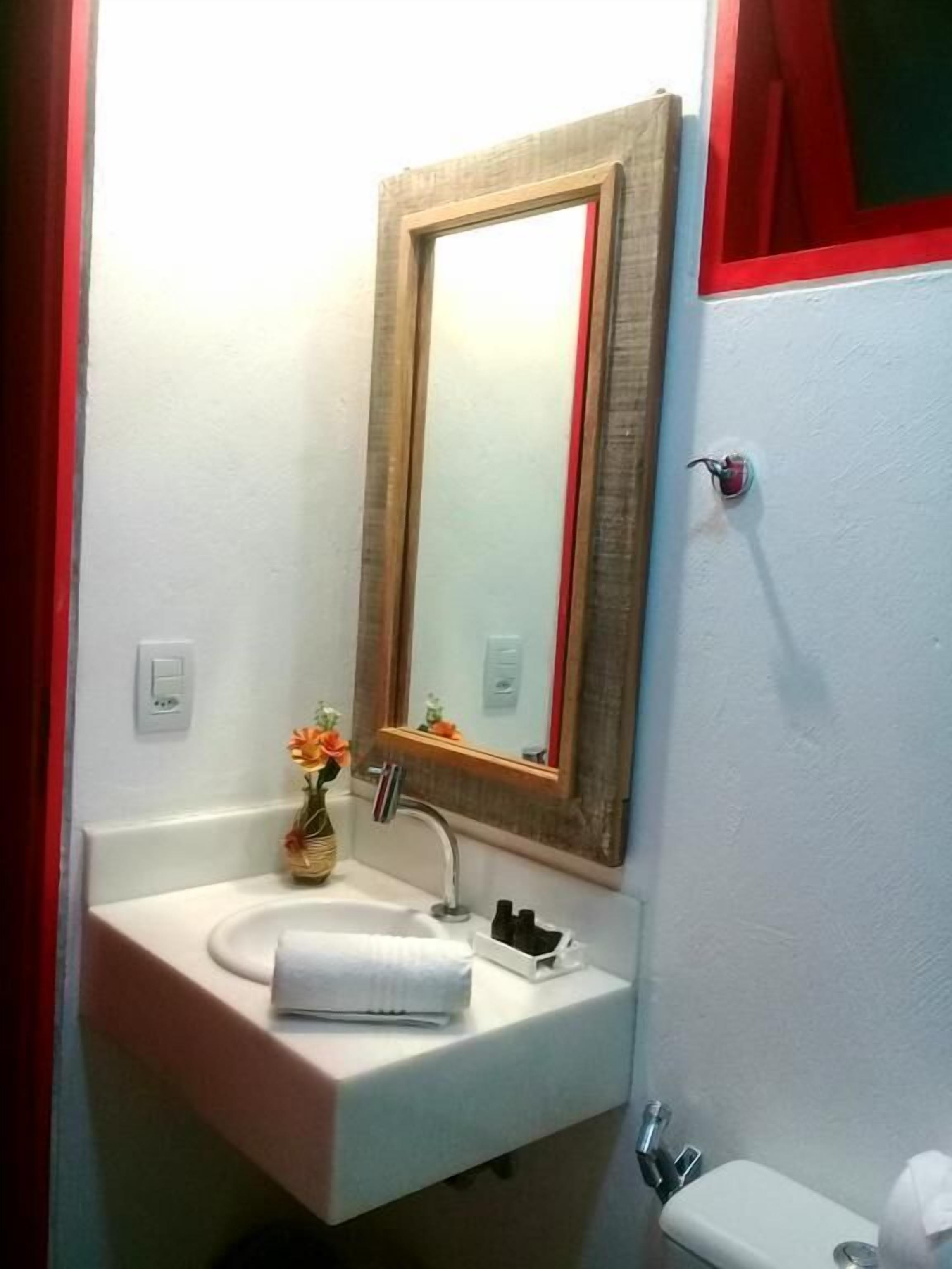 A bathroom with a white sink, a mirror, and a toilet.