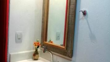 A bathroom with a white sink, a mirror, and a toilet.