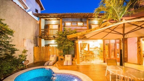Un espace aménagé au bord de la piscine, comprenant un jacuzzi, des chaises longues et une terrasse couverte.