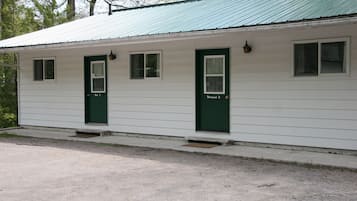 A row of two-room cabins with green doors and windows, each labeled "Room 2".
